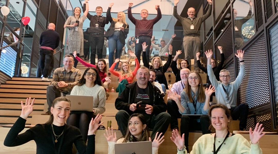Eine Gruppe begeisterter Splunker mit erhobenen Händen in einem Amphitheater-ähnlichen Meeting-Bereich in einem unserer Büros.