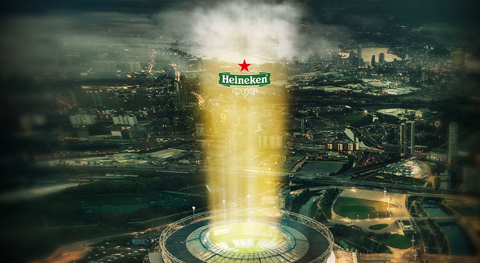황혼의 도시 경관에 겹쳐진 Heineken 유리잔