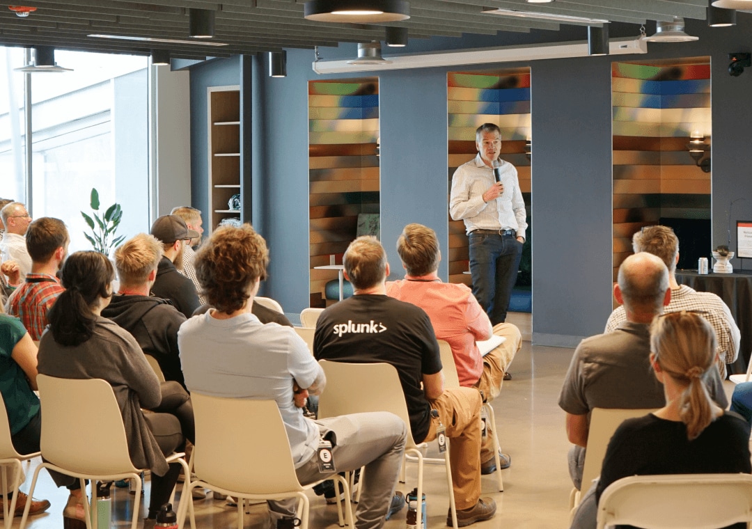 Un directeur anime une session de développement professionnel avec un public de Splunkers.