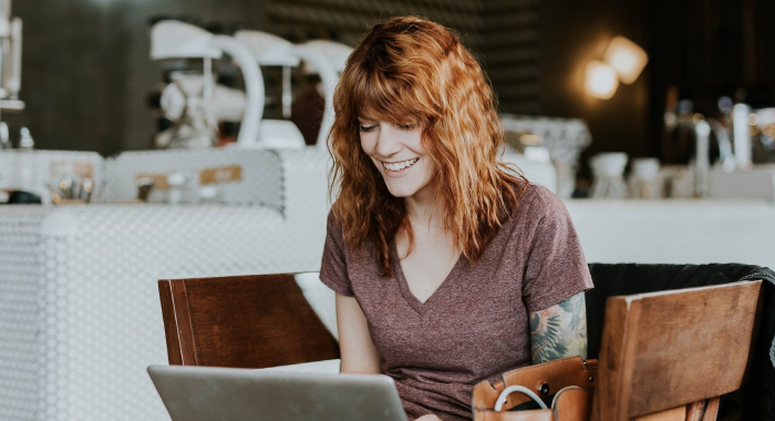  A Splunker works on her laptop seated in a chair at a cafe.