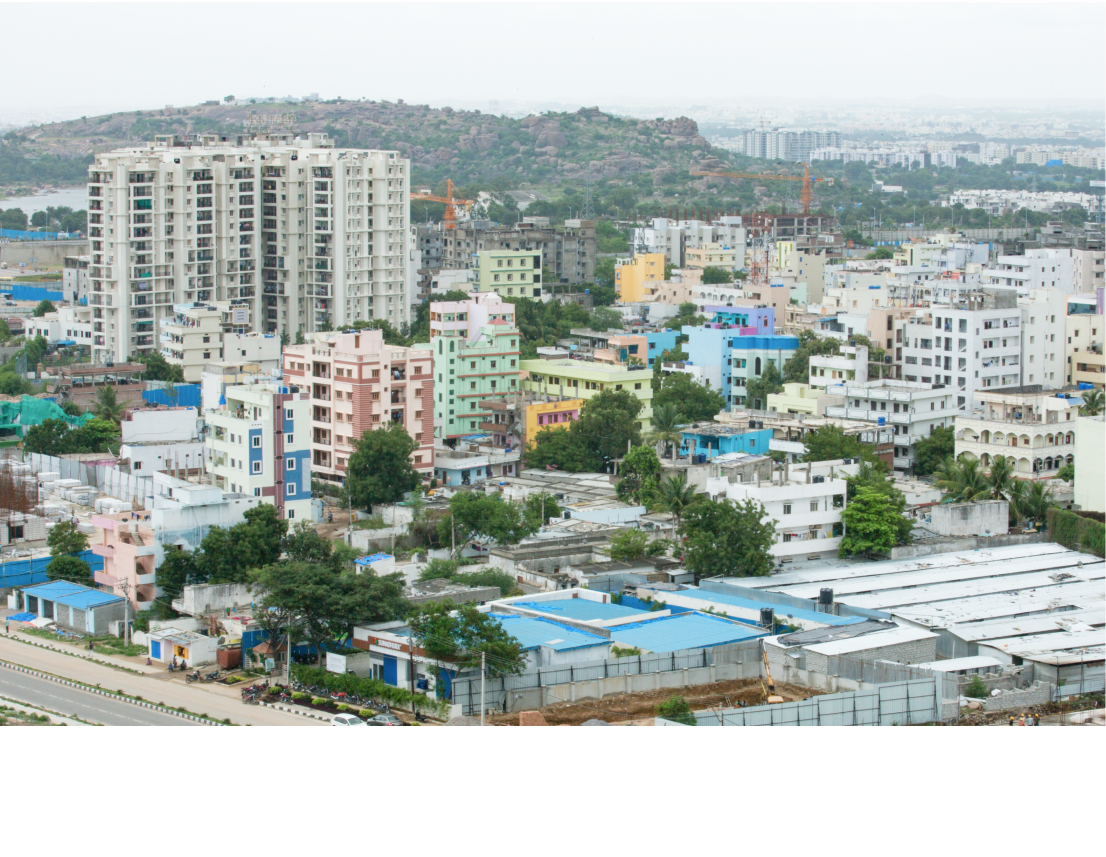 Multicolored high rises spread across Hyderabad, interspersed with trees.