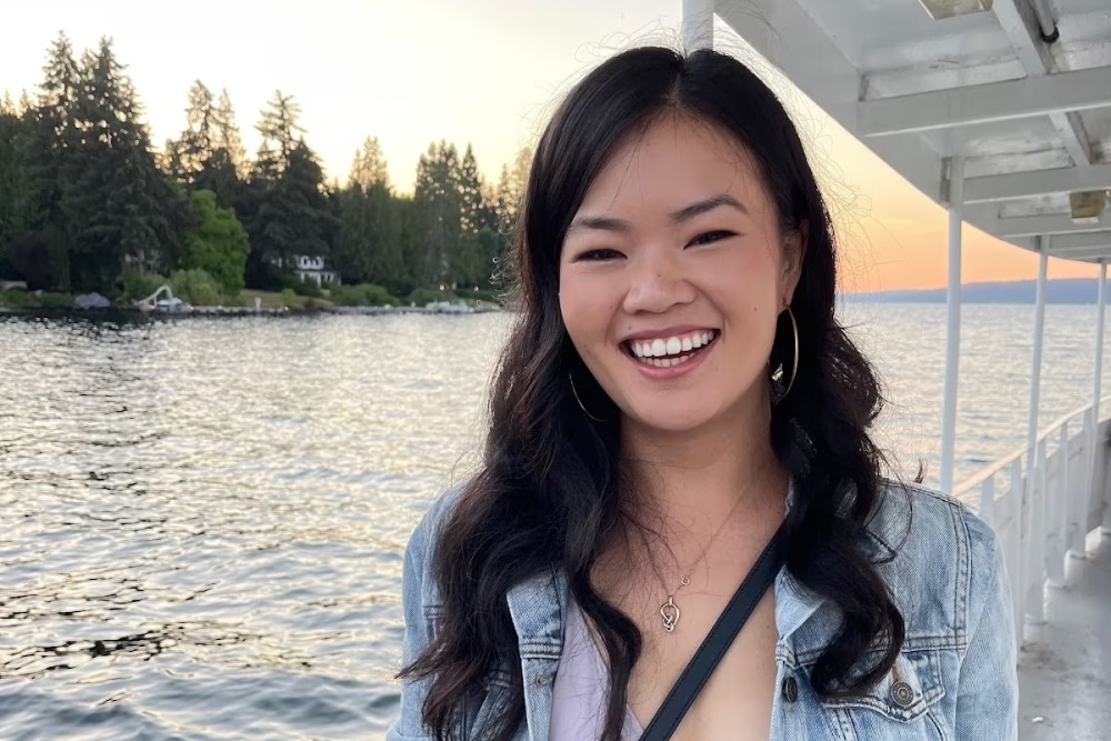 Splunk’s product management intern Kelsey King smiles while riding on a ferry, framed by water and the shore in the distance.
