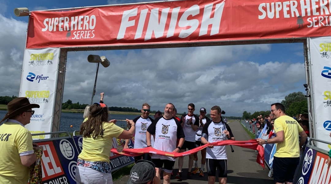 Splunkers crossing the finish line at the Super Hero Series race wearing their Splunk Veterans Employee Resource Group t-shirts.