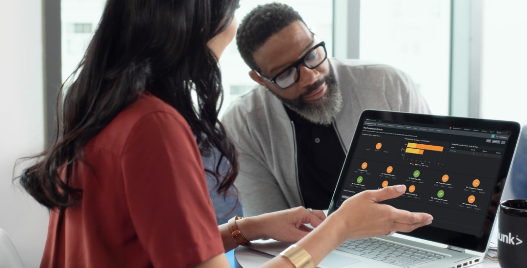 Deux Splunkers autour d’un ordinateur portable apprennent à utiliser Splunk.