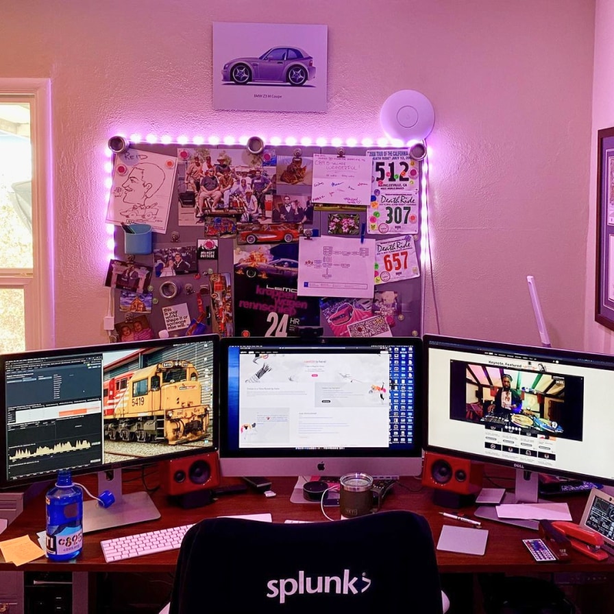 A cozy desk space with a personalized bulletin board and three large-screen monitors shows how a Splunker created their own ideal work environment.