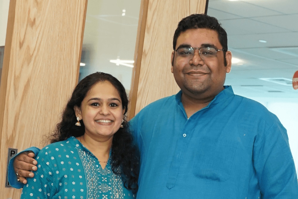 Eine Mitarbeiterin und ein Mitarbeiter stehen lächelnd im Büro von Splunk in Hyderabad.