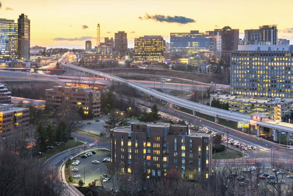 Several highways criss cross between tall, illuminated commercial buildings at sunset. The Splunk office in McLean, Virginia is just steps from Washington, DC.