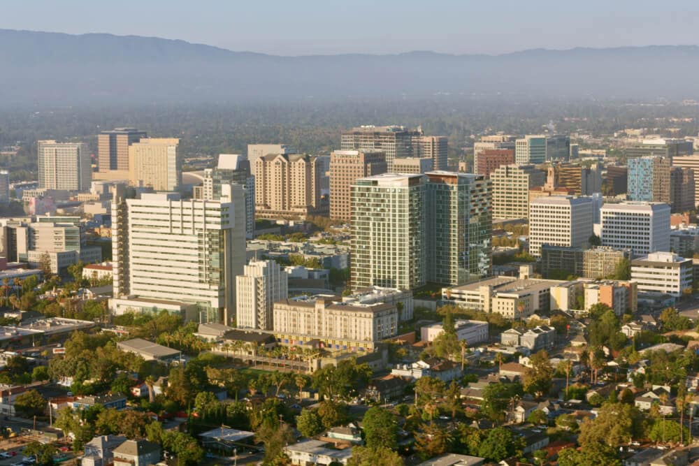 Eine Gruppe von beigen und braunen Geschäftsgebäuden in einem Tal mit Bergen in der Ferne. Splunk hat ein Büro in San Jose, Kalifornien.