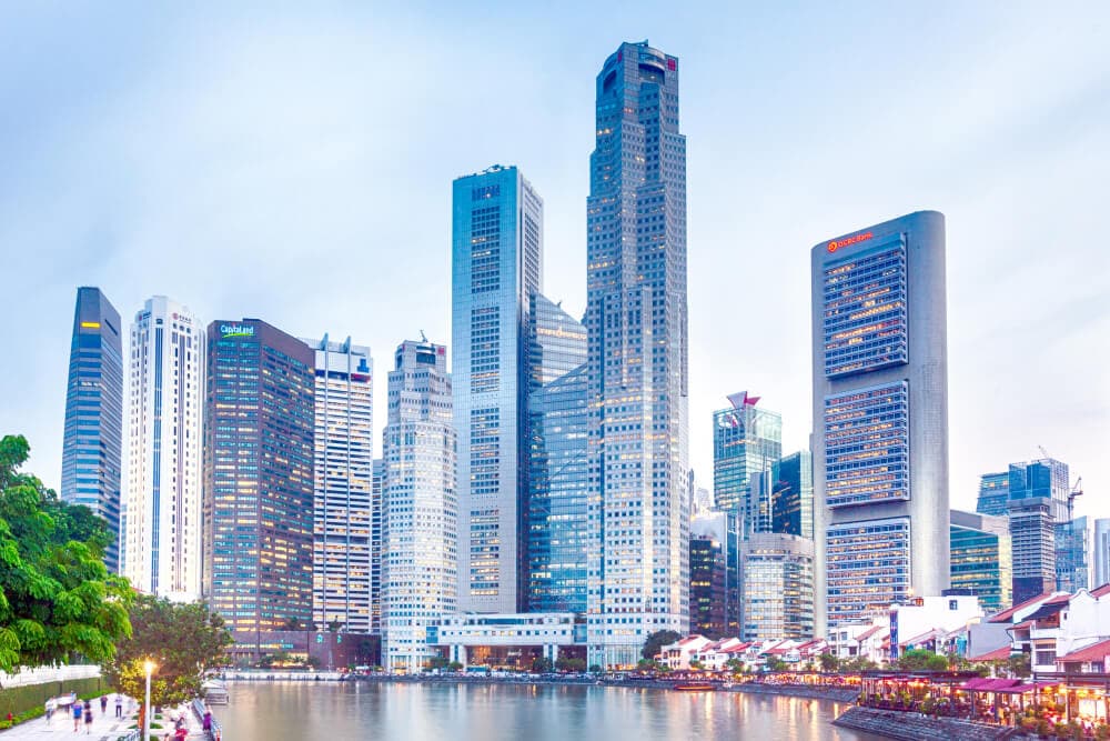 Two interconnected skyscrapers rise above a cluster of commercial buildings in front of a cove. Splunk has an office in Singapore. 
