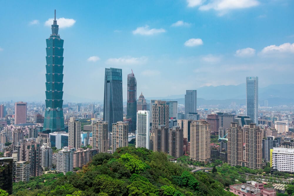 Splunkは台湾の台北にオフィスを構える。草木が青々と茂る長方形のエリアの周囲に茶色い高層ビルが立ち並び、その向こうにブルーのクロム調の超高層ビルがそびえ立つ。