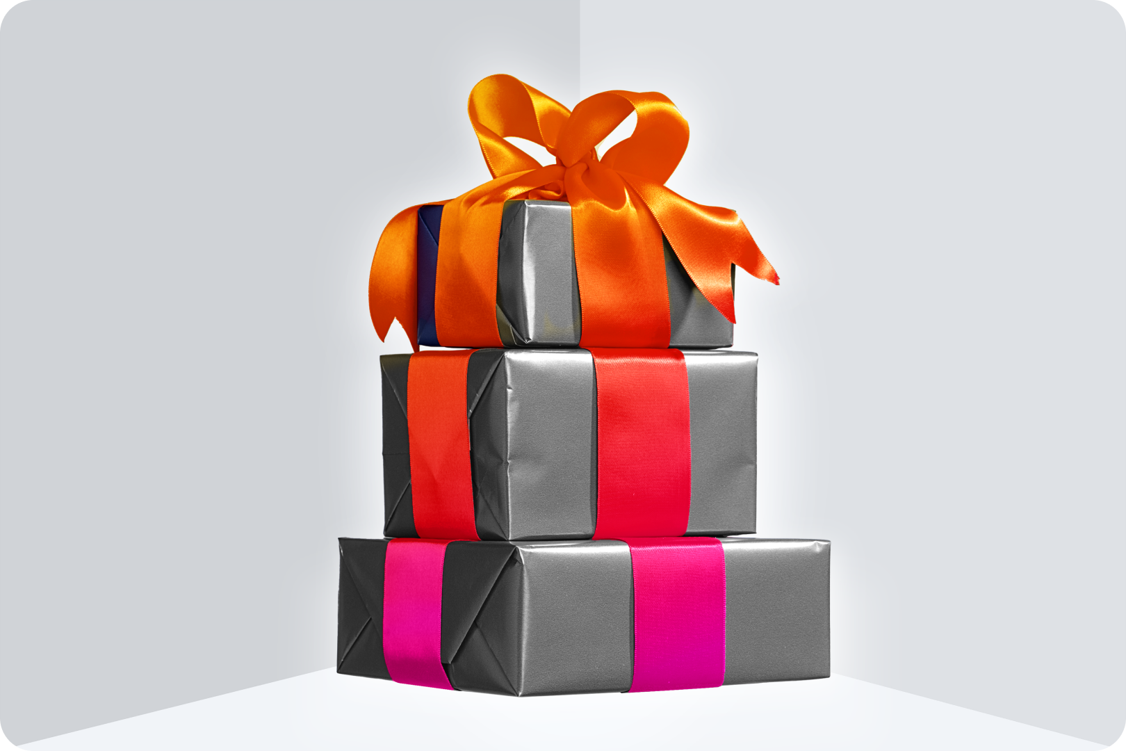 A black and white image of a stack of gift boxes, with a gradient ribbon. 
