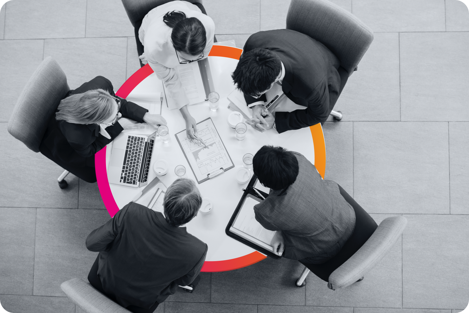 An overhead view of a team on a circular desk collaborating. 
