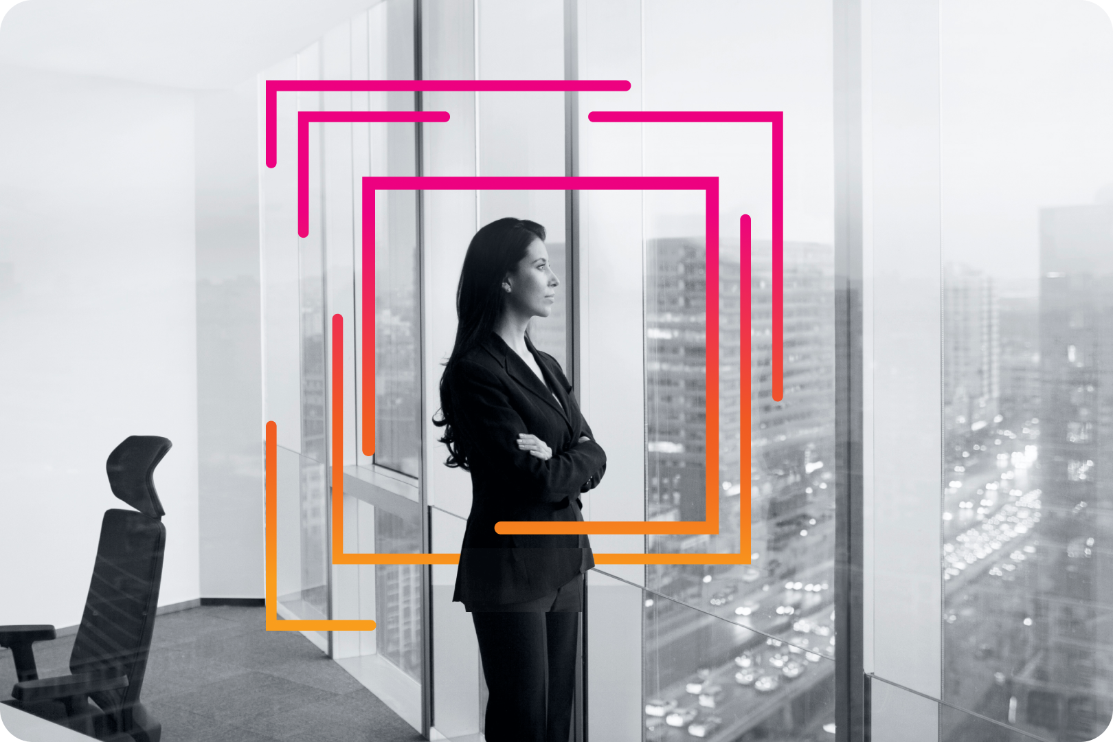 A standing woman looks out the window of a board room