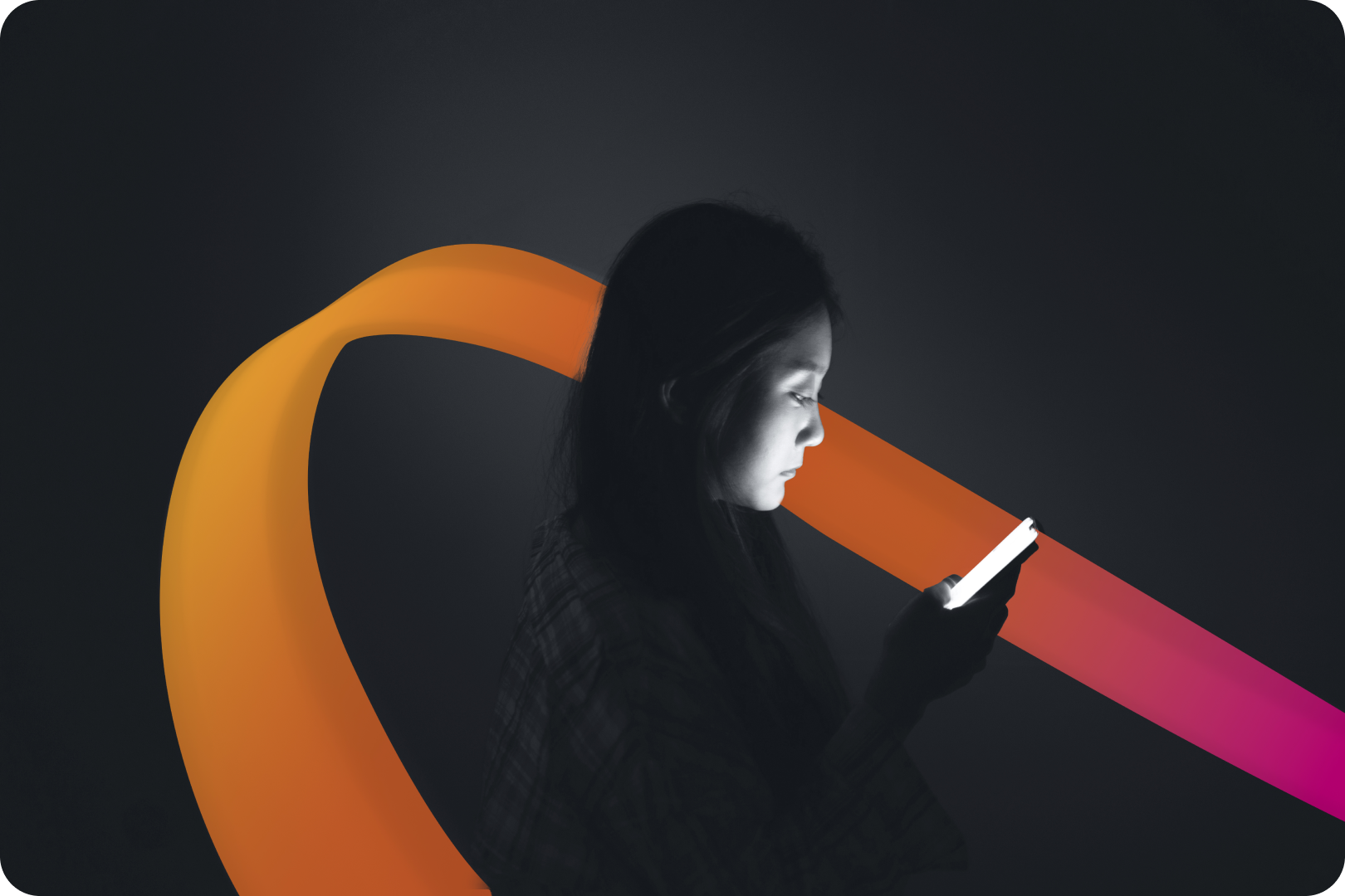 Side profile of a woman examining a device against dark background.